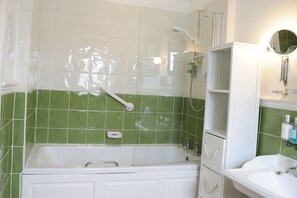 A bathroom with a bathtub, a shower, and a sink.