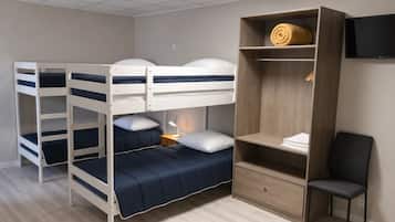 Habitación con literas, escritorio, silla, televisión y un armario de madera.