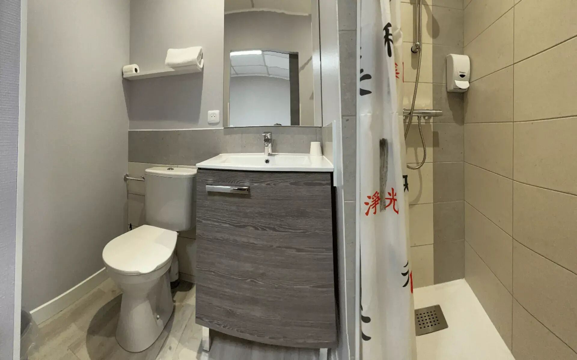 Ein modernes Badezimmer mit Toilette, Waschbecken und Dusche.