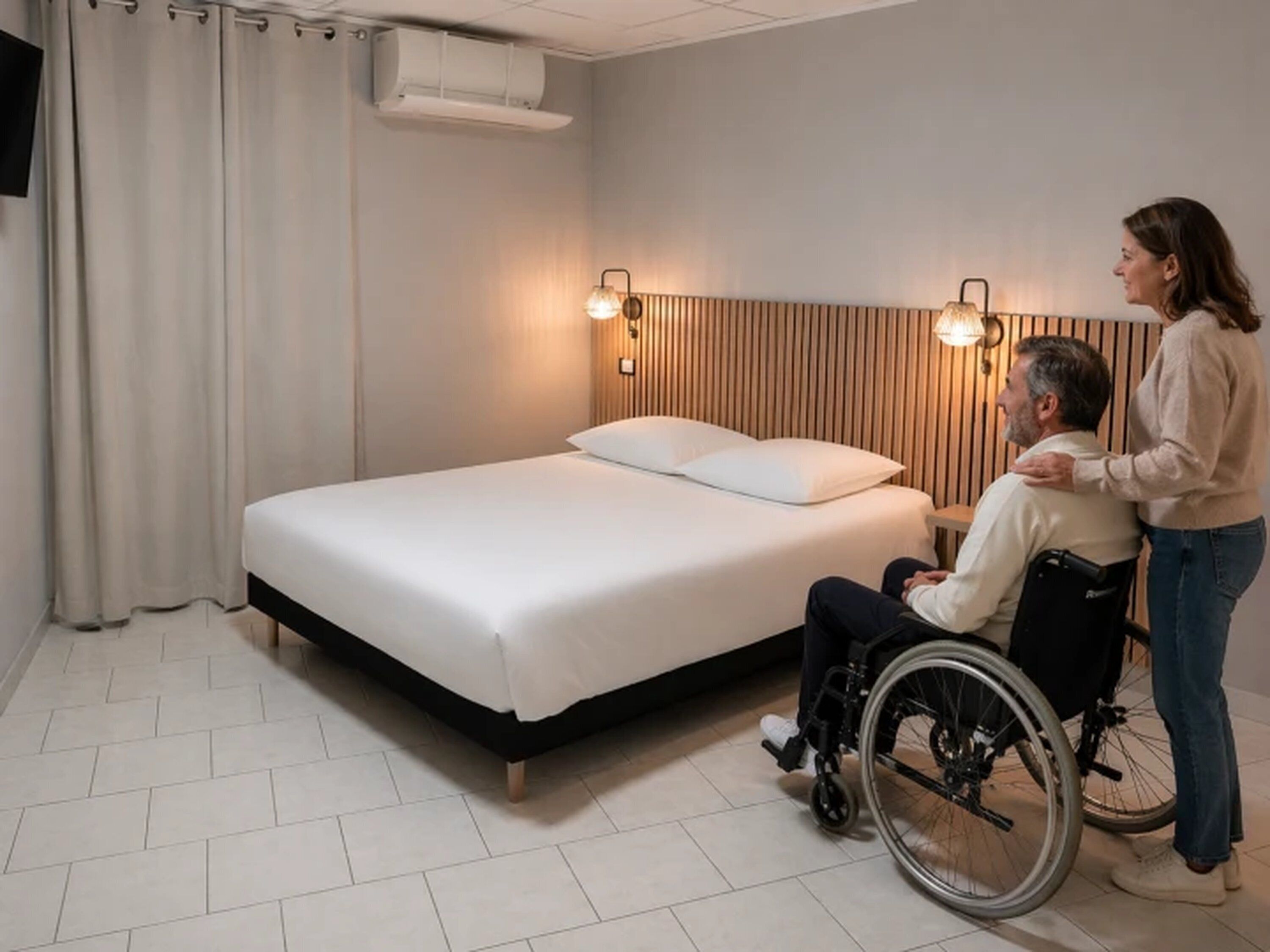 A bedroom with a bed, two wall-mounted lights, a window with curtains, and a wheelchair.