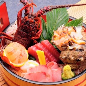 Un piatto di mare con diversi tipi di pesce e una coda di aragosta.