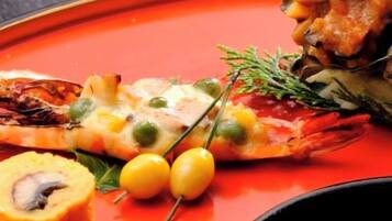 A plate with a grilled item, possibly a fish, accompanied by a small round object and two yellow berries.