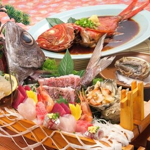 Une variété de fruits de mer, notamment un poisson entier, des crabes et des huîtres, présentés sur un plateau en bois.