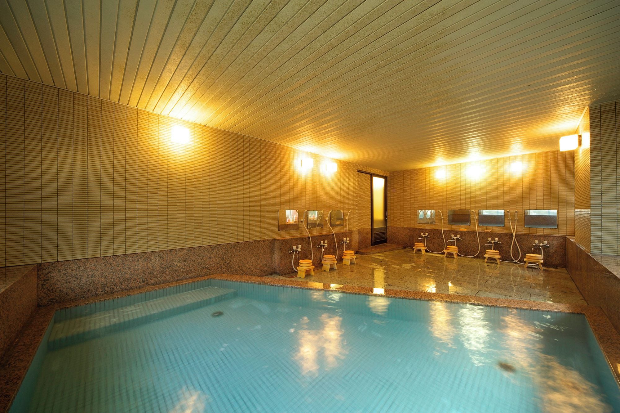 An indoor swimming pool with multiple changing rooms and showers.