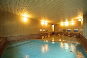 Ein Hallenbad mit mehreren Umkleidekabinen und Duschen.
