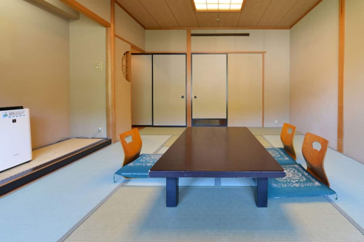 Ett traditionellt japanskt mötesrum med tatamimattor, ett lågt bord och skjutdörrar.