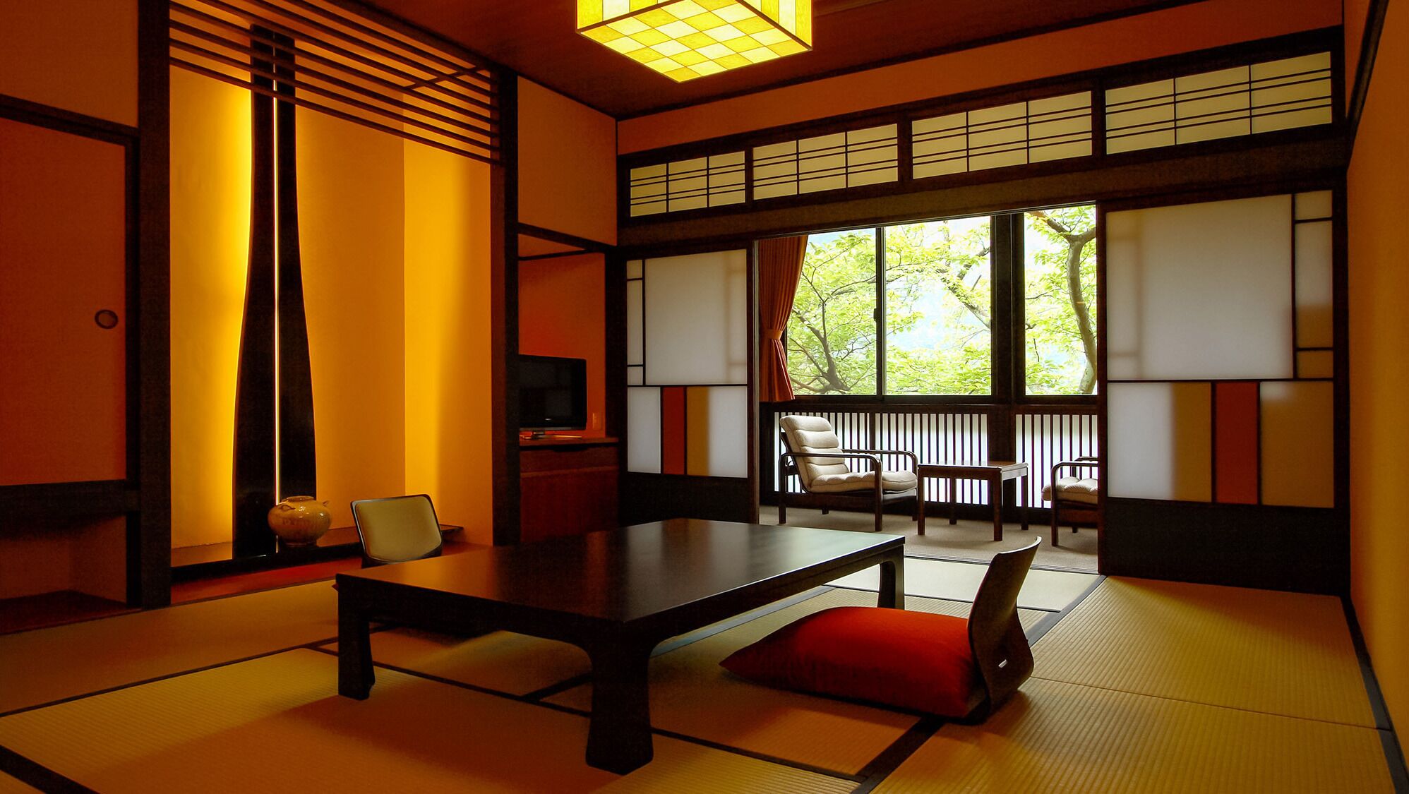Una habitación japonesa tradicional con suelo de tatami, una mesa baja y puertas correderas.