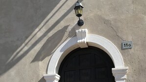 A black door with a white archway, a small light fixture above it, and a number plate '11G' on the wall. - Ca' Pignoi (Garda)