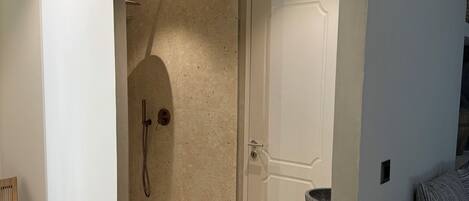 A modern bathroom with a shower, a sink, and a toilet.