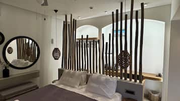 Un dormitorio moderno con una cama, un espejo redondo y un separador de madera.
