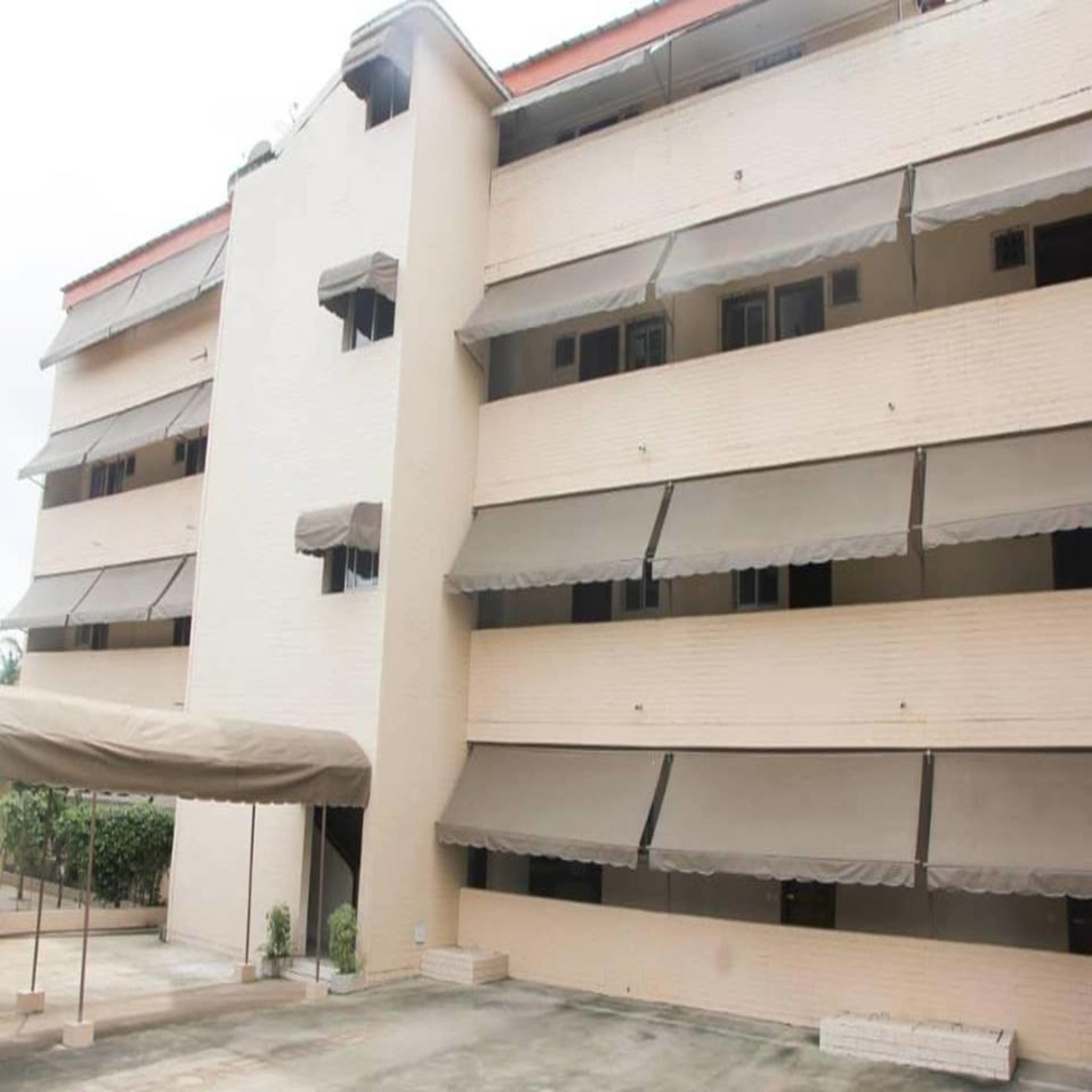 A multi-story building with balconies and awnings.