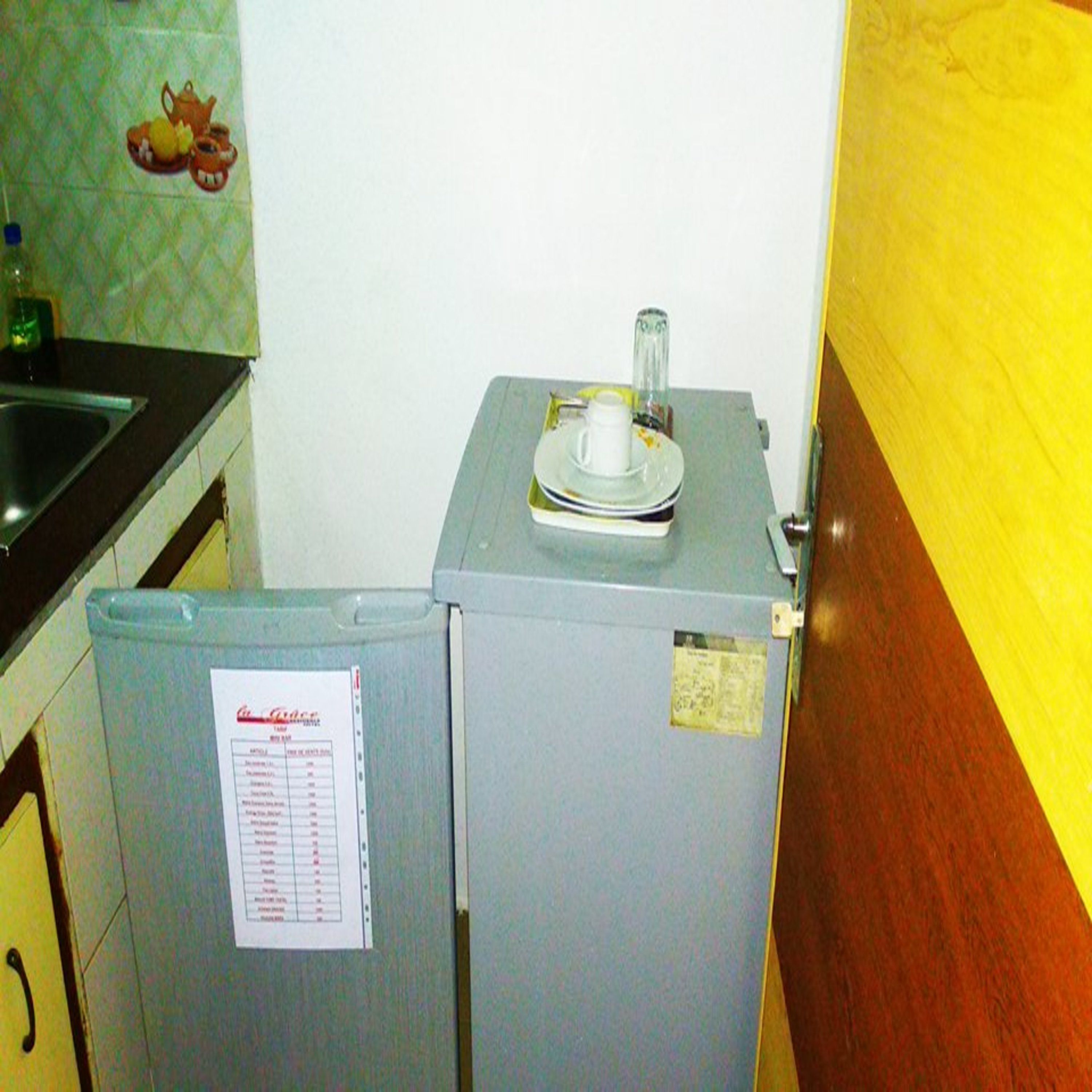 A compact kitchen with a refrigerator, a sink, and a small countertop.
