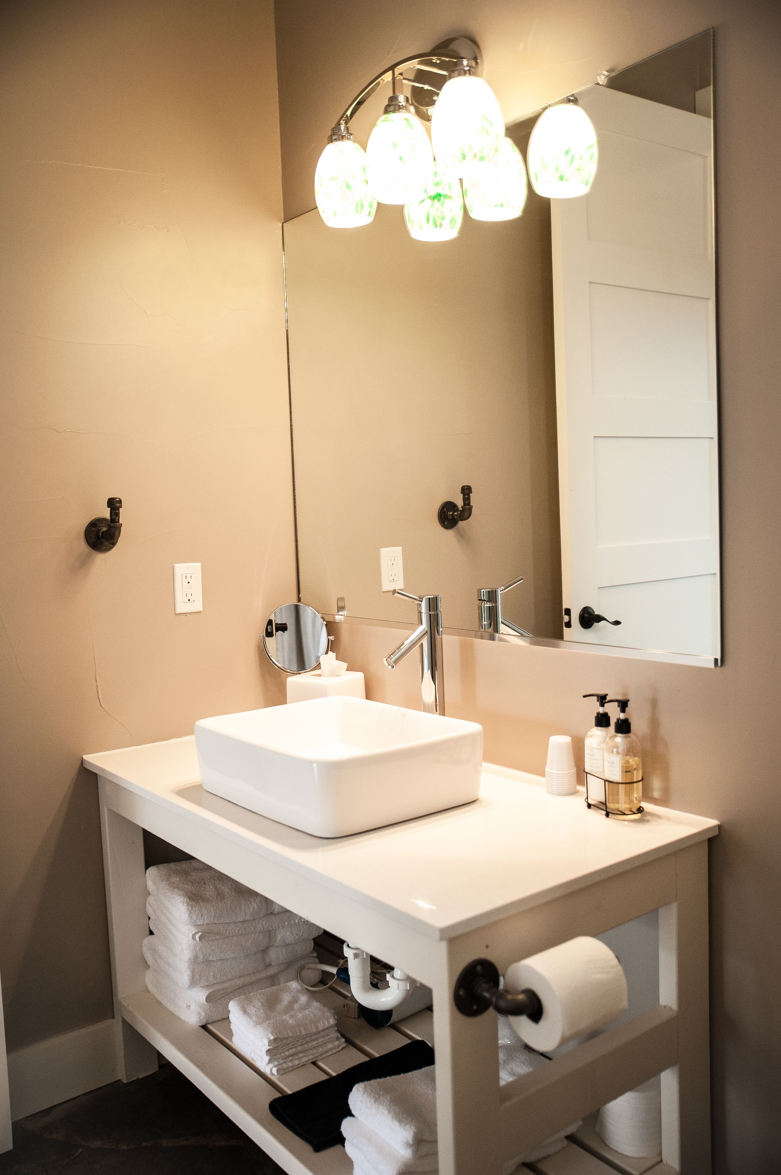 A bathroom with a white sink, mirror, and towel rack.