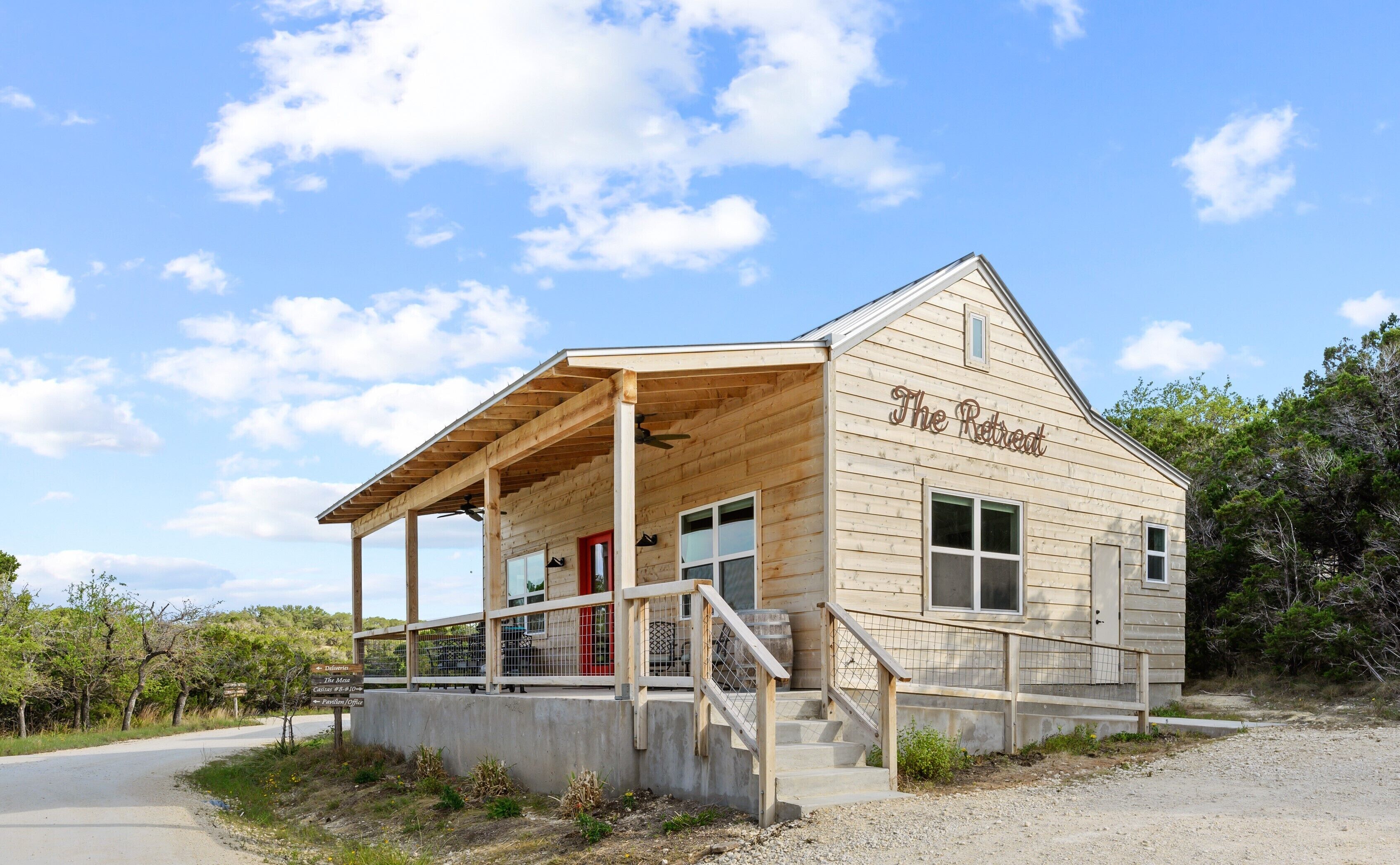 A wooden building with a porch and a sign that reads "The Retreat."