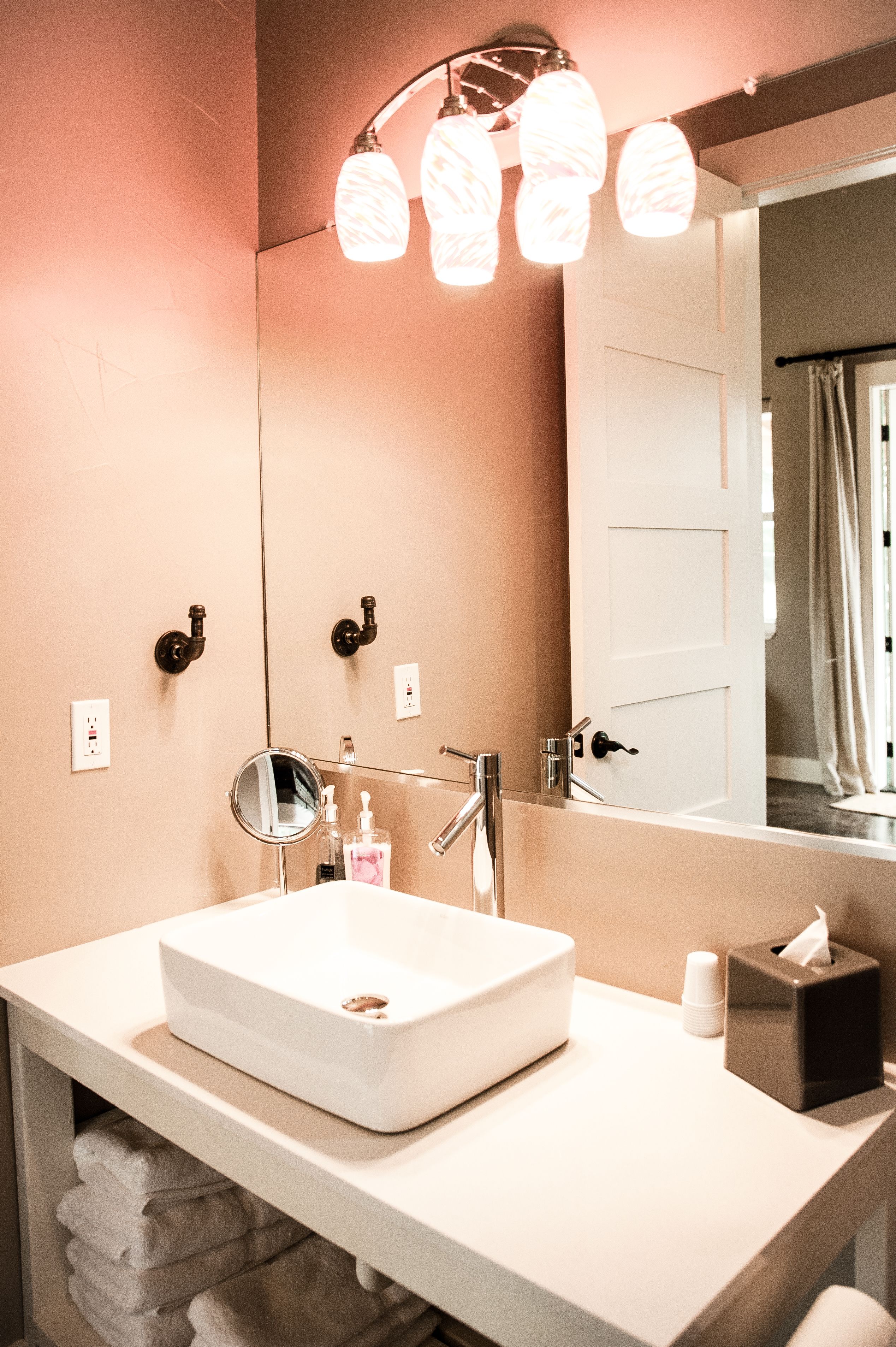 A bathroom with a white sink, a mirror, and a towel rack.