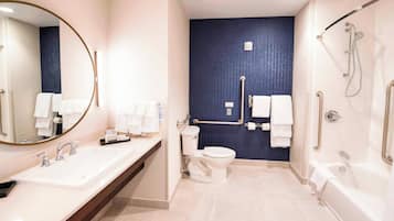 A modern bathroom with a large sink, toilet, and bathtub.