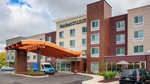 A Fairfield Inn & Suites by Marriott hotel with a modern design, featuring a covered entrance and multiple windows.