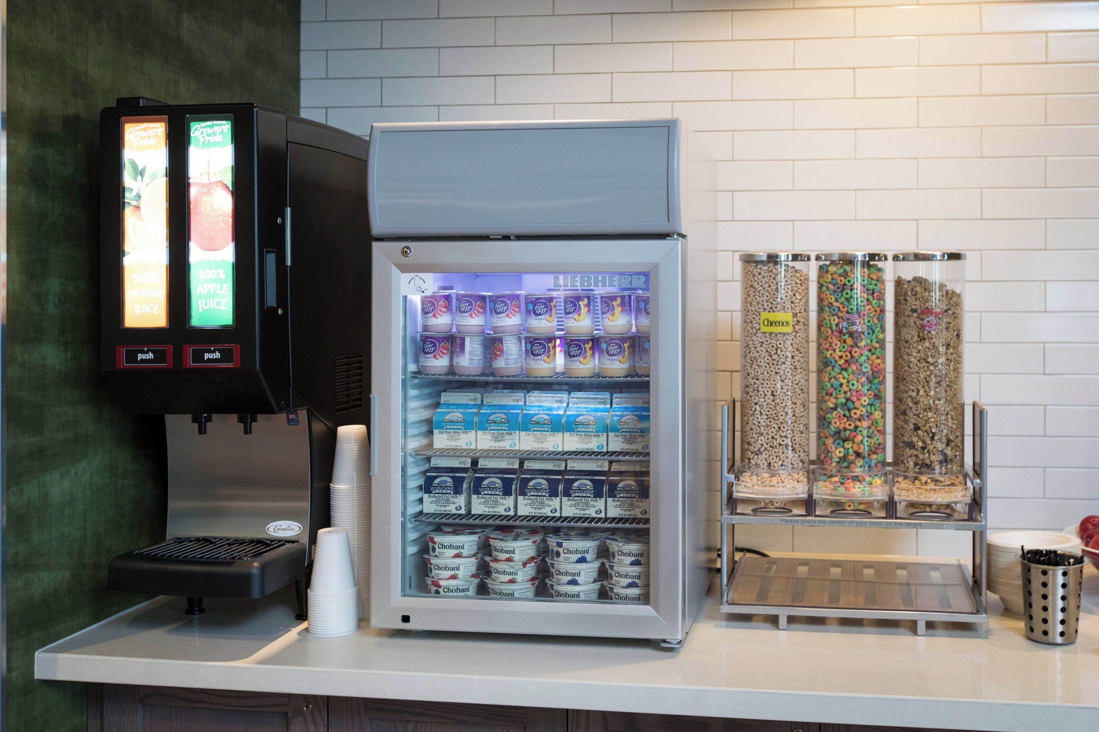 En selvbetjeningsstation til drikkevarer med kaffemaskine, køledrikkeautomat og havregryn.