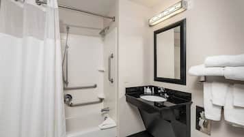 A modern bathroom with a bathtub, shower, and vanity.