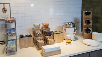 A breakfast bar with various food items and a coffee station.