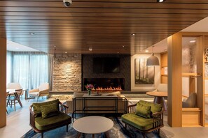Un moderno salón con chimenea de piedra, techo de madera y asientos confortables.