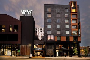 Ein modernes Hotel mit einem auffälligen Schild für 'Finnegans House' und 'Elliot Park Hotel'.