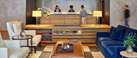 A reception area with a reception desk, two sofas, a coffee table, and a checkered floor.