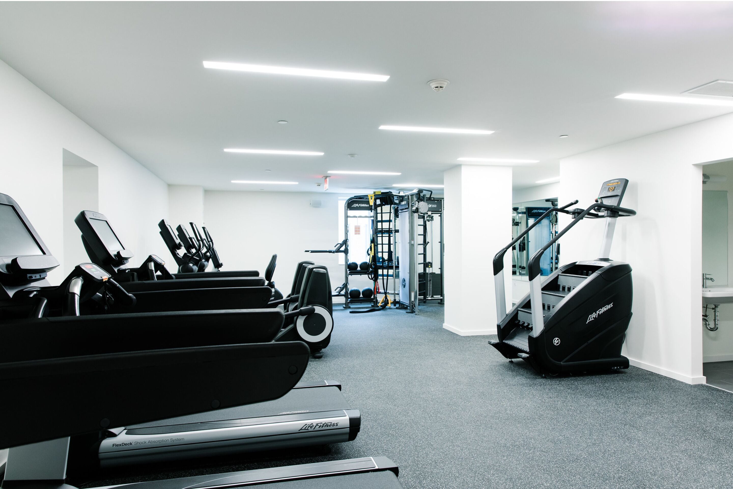 A gym with treadmills, a stair climber, and weight machines.