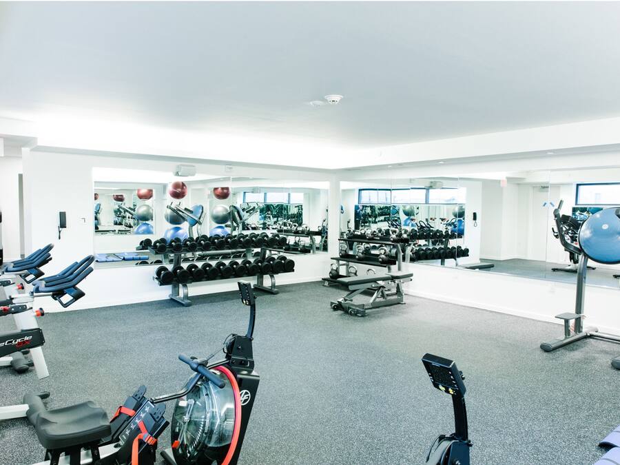 Una sala de gimnàstica equipada amb maquinària cardiovascular, aparells de musculació i peses.