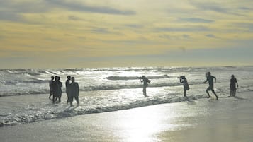 A beach scene with people walking along the shore.