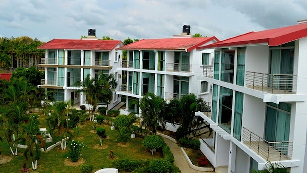 A modern hotel with multiple floors, large windows, and a red roof. - Inani Royal Resort (Cox's Bazar)
