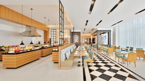 A modern hotel lobby with a long reception desk, a checkered floor, and a seating area with tables and chairs. - Fairfield by Marriott Sriperumbudur (Sriperumbudur)