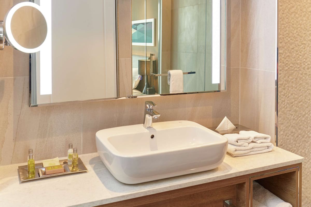 designer toiletries, hair dryer, slippers, towels
