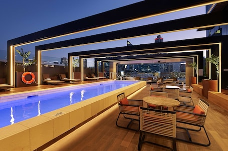 Una piscina al aire libre, sillones reclinables de piscina