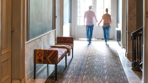 A grand hallway with a patterned carpet, benches, and a large chandelier. - Boutique Hotel Catshuis (Leeuwarden)