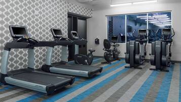 A gym with treadmills, elliptical machines, and stationary bikes.