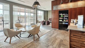 Eine moderne Hotelhalle mit Sitzgelegenheit, einer Rezeption und einer Speisekarte.