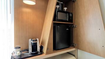 Une petite cuisine équipée d’une machine à café, d’un four à micro-ondes et d’un réfrigérateur.
