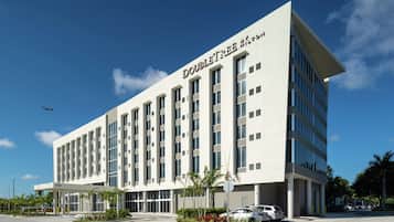 A modern hotel with a flat facade, multiple windows, and a clear sky.