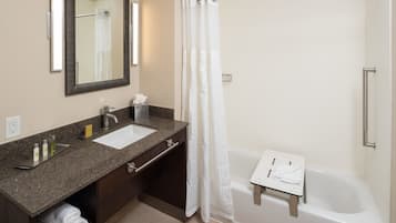A bathroom with a sink, mirror, towel rack, and a shower with a curtain.