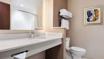 A modern bathroom with a white sink, a mirror, a towel rack, and a toilet.