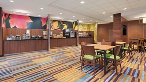 A hotel lobby with a reception desk, seating area, and a colorful carpet. - Fairfield Inn & Suites by Marriott Charlottesville Downtown/University Area (Charlottesville)