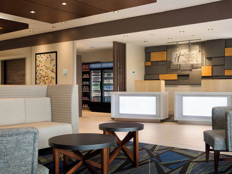 A lobby area with seating, a reception desk, and a refrigerator stocked with beverages.