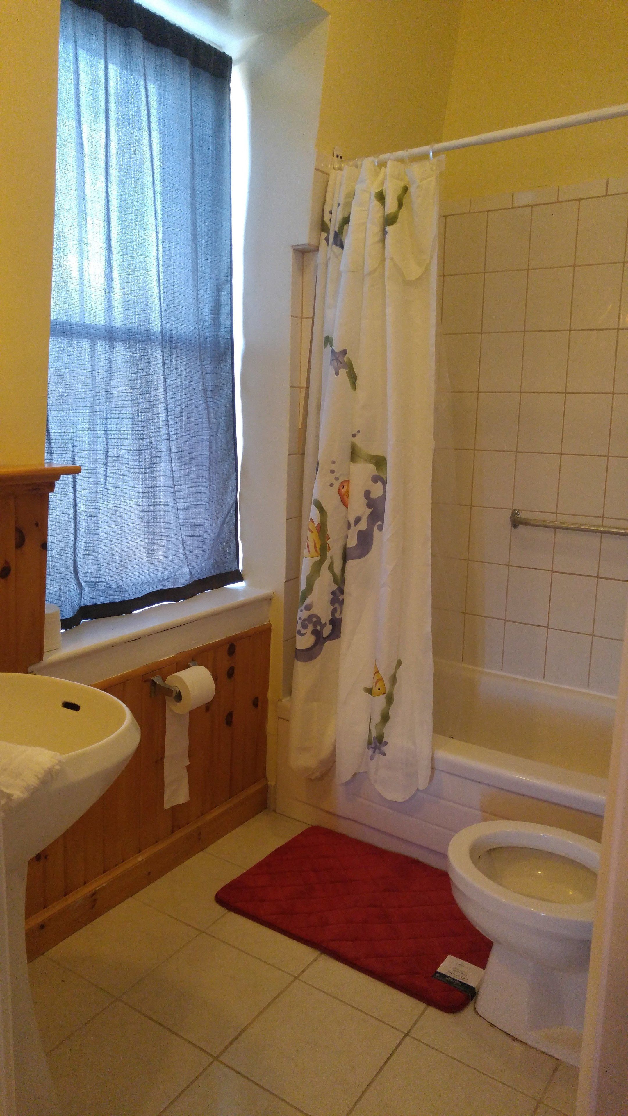 A bathroom with a sink, toilet, and bathtub.