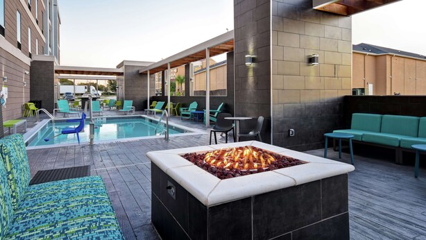 A rooftop pool area with a fire pit, lounge chairs, and seating. - Home2 Suites by Hilton Fort Worth Fossil Creek (Fort Worth)