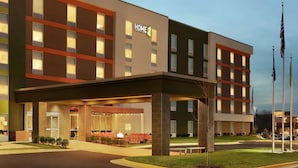 Un hôtel moderne doté d’une entrée couverte, de plusieurs étages et d’une façade bien éclairée.