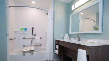 A modern bathroom with a walk-in shower, a vanity with a mirror, and a bathtub.