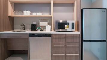A modern kitchen with a dishwasher, microwave, and refrigerator.
