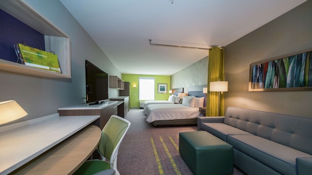 A hotel room with a desk, chair, bed, sofa, and a TV. - Home2 Suites by Hilton Jackson Flowood Airport Area (Flowood)