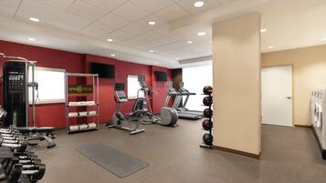 A gym with treadmills, elliptical machines, and weight equipment.